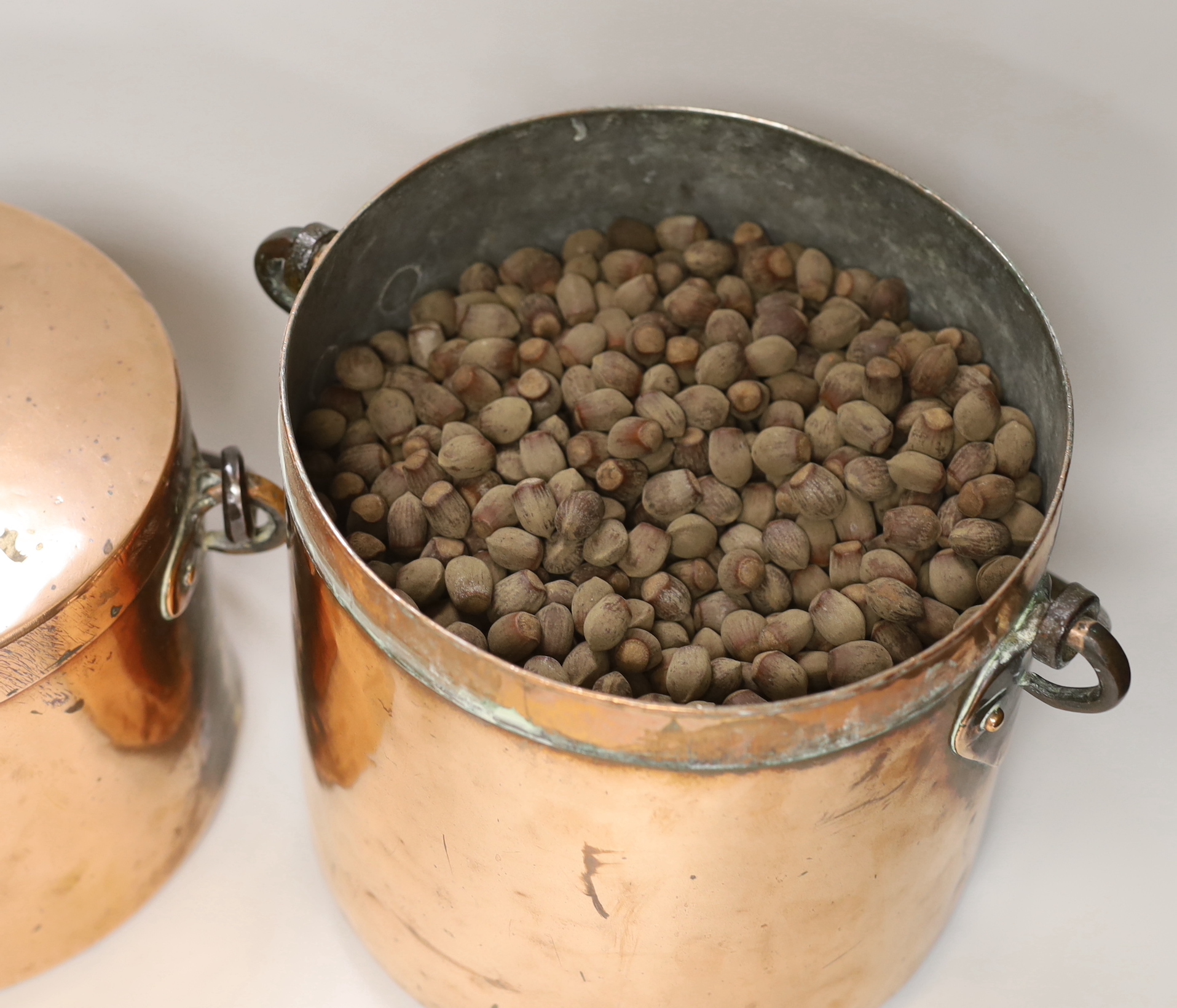Two Victorian copper lidded vessels, with wrought iron swing handles, largest 25 cm high with the swing handle down
